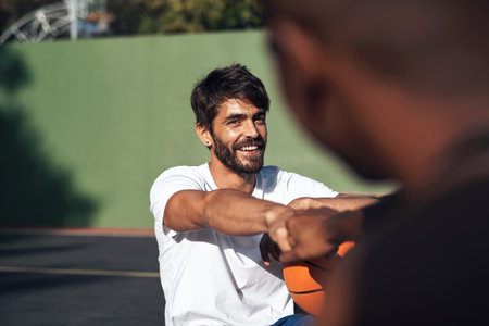 Your skills on the court are so good. a sporty young man giving his teammate a fist bump on a basketball court.の写真素材