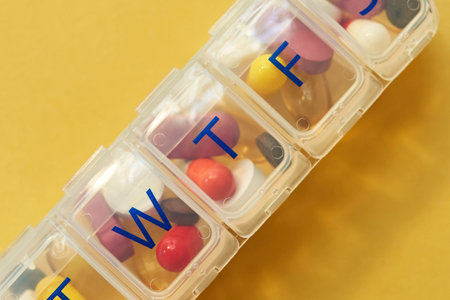 Did you take your pills today. Studio shot of tablets in a medicine organizer against a yellow...