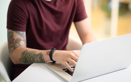 Lets get this productive day started. Closeup shot of an unrecognisable businessman working on a laptop in an office.の写真素材
