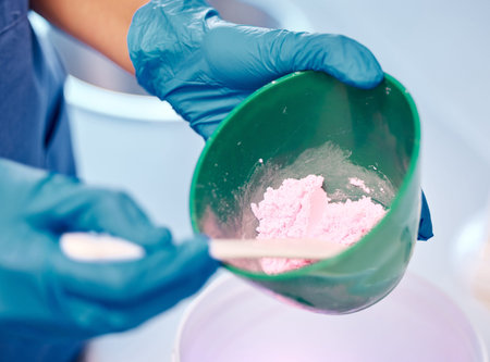 The highest quality products only. a dentist mixing a bowl of powder before a procedure.