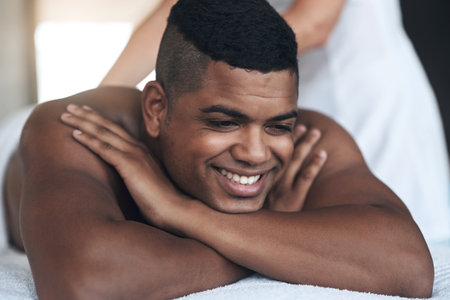 This sure feels good. a young man getting a back massage at a spa.の写真素材