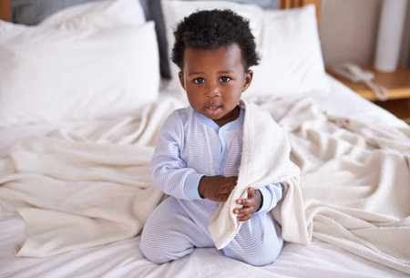 Happy, portrait and baby with a blanket in bed, waking up and playing in his home. Face, sweet and...
