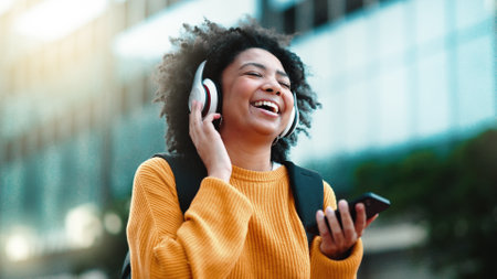 Headphones, phone and black woman in city dancing to music in outdoor lens flare for student lifestyle and wellness. Urban, gen z person dance and listening to audio tech on mobile app, 5g smartphoneの写真素材