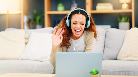 Au pair using laptop and headphones for video call to connect and communicate with family and...