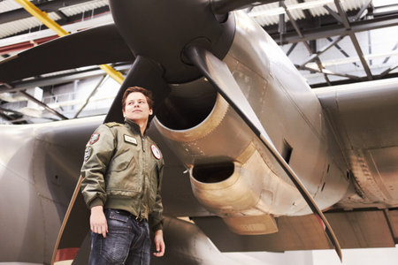 Army, jet and man pilot or combat plane or low angle in front of propeller and in navy uniform on...