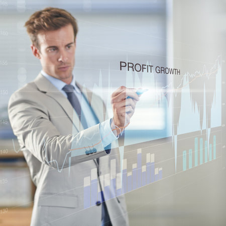 Expanding your profit margin. a businessman using a digital interface.の写真素材
