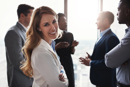 They always come up with some interesting ideas. Cropped portrait of an attractive businesswoman standing with her arms folded during a meeting in the boardroom.の写真素材