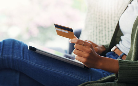 Some much needed retail therapy. an unrecognizable woman using a tablet for online shopping while sitting on the sofa.の写真素材