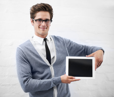 Put your text in his capable hands. A nerdy guy holding a digital tablet.の写真素材