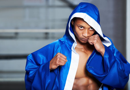 Steel in his eyes. An african american boxer with his fists up and a determined look in his eye.の写真素材