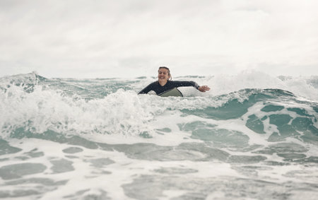 Youll never forget the feeling of riding a wave. a young woman out surfing at the beach.の写真素材