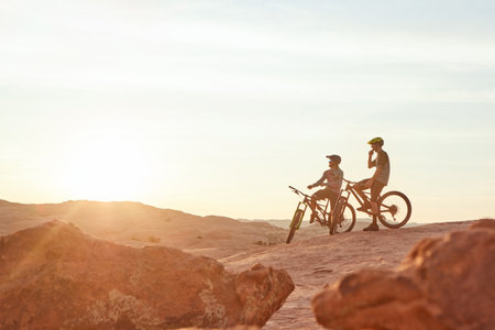 The best way to explore nature. Full length shot of two young male athletes mountain biking in the wilderness.の写真素材