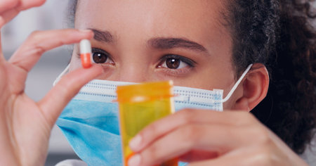 Ive completed the cure. a young scientist holding a pill in her hand while working in a lab.の写真素材