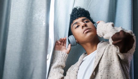 Music that speaks to the hidden part of your soul. a young man using headphones to listen to music...