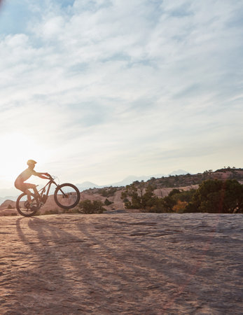 Everything is a lot more beautiful when you go on two wheels. a young man out mountain biking during the day.の写真素材