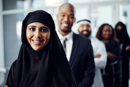 I love it when a plan comes together. Cropped portrait of an attractive young arabic businesswoman standing at the head of a line of her colleagues.の写真素材