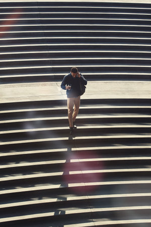 He does it all with one call. a young businessman using a mobile phone while walking through the...