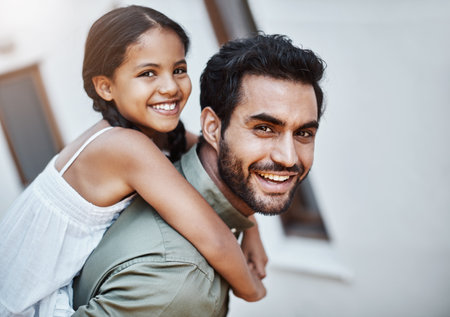 Nothing but fun with the two of them around. a happy father and daughter enjoying a piggyback ride together outdoors.の写真素材