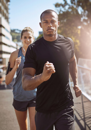Serious about fitness. two young people talking a run in the city.の写真素材