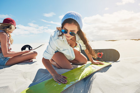 Shes a seasoned sand boarder. a young woman sand boarding in the desert.