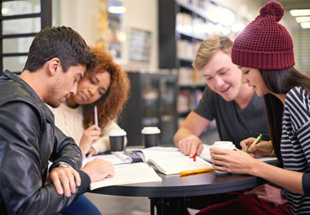 Students study in a group in library, people learning for university education and scholarship. Academic development, knowledge with young men and women studying for exam, research and reading bookの写真素材