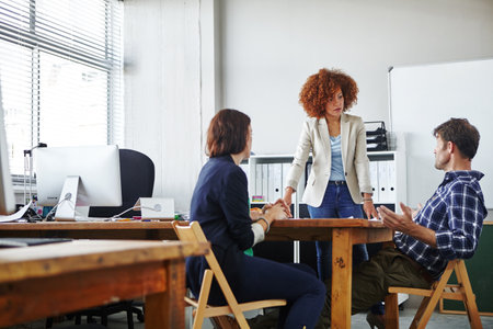 Anyone got any thoughts. three colleagues discussing business in the office.の写真素材