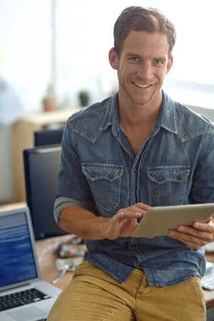 Doing some project planning online. A young man reading his text messages while standing in his...