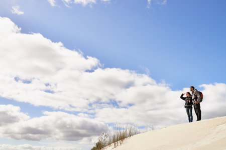 Sharing their love of wild places. a happy couple hiking in the dunes together.の写真素材