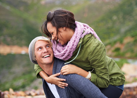 Hes my love and best friend. an attractive young couple enjoying a piggyback outdoors.の写真素材
