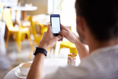 I got us a table. a man using his mobile phone while sitting at a restaurant table.