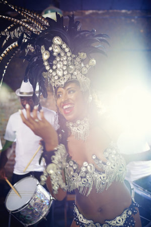 Performing a live show. a beautiful female dancer and her band enjoying their performance.