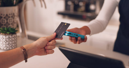 Pos, hands of woman and payment with credit card in coffee shop with barista at counter with...