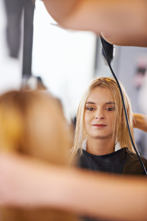 Its amazing what a little styling can do. a woman having her hair styled at a salon.