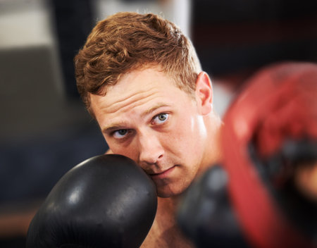 Perfecting his punch. A young boxer throwing a punch at his partners sparring glove.