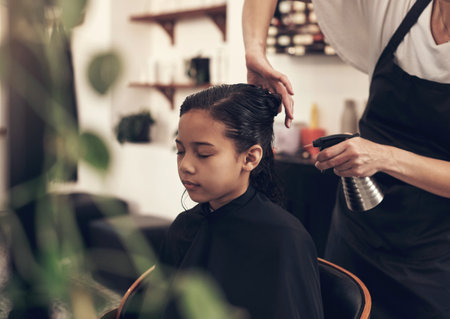 I cant wait to tell my friends about my trip to the salon. a little girl getting her hair done at the salon.の写真素材