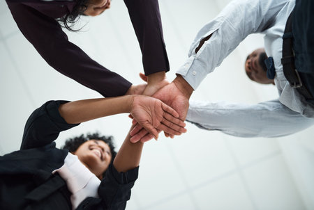 Hard work beats talent when talent fails to work hard. a group of unrecognizable businesspeople joining their hands together in a huddle.の写真素材