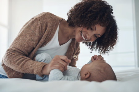 My love for you is immeasurable. a young woman playing with her adorable baby girl on the bed at home.の写真素材