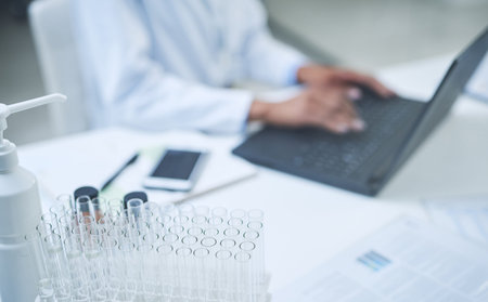 Getting hands on in giving the world a second chance. an unrecognisable scientist using a laptop to...