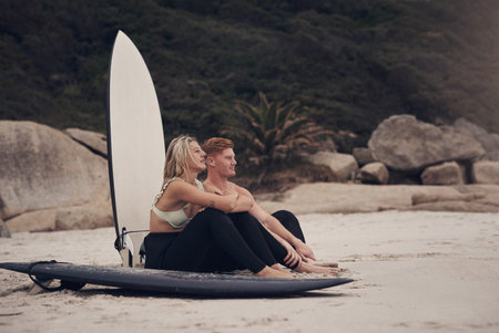 Theyre focused on one thing, catching the perfect wave. a couple out at the beach with their...