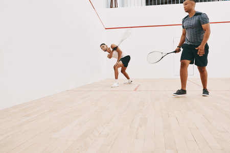 Agility is your best friend in this game. two young men playing a game of squash.の写真素材