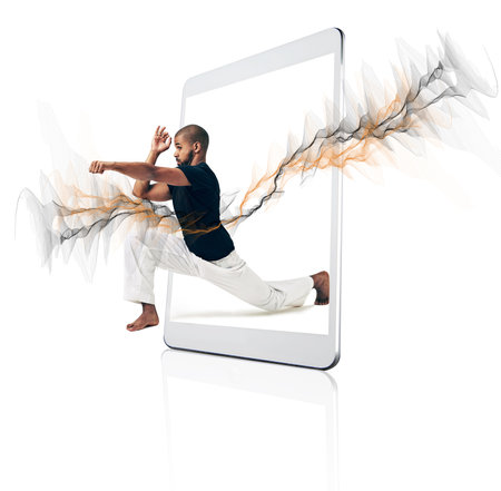 Karate, technology and man with fitness, routine and model isolated against a white studio background. Male person, athlete and guy with smartphone, mobile app and training for wellness and healthの写真素材