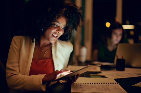Shes a savvy problem-solver. a businesswoman using a digital tablet in an office at night.の写真素材