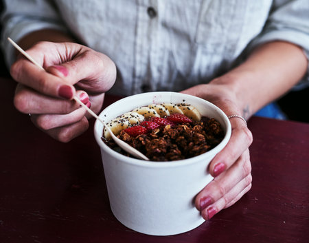 Always start your day with breakfast. an unrecognizable woman having a bowl of granola.の写真素材