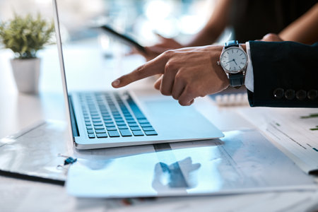 These are results I like to see. an unrecognizable businessman sitting with his colleague and using his laptop in the office.の写真素材