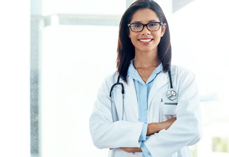 Nothing makes me happier than seeing you well. Portrait of a confident young doctor working in a modern hospital.の写真素材