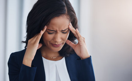 Facing the stresses of the day. a young businesswoman looking stressed out in an office.の写真素材