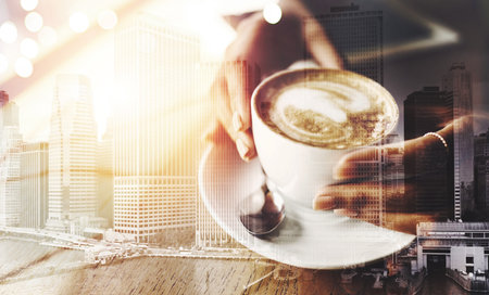 Coffee makes everything possible. Closeup shot of an unrecognizable woman having a cup of coffee at a cafe.の写真素材