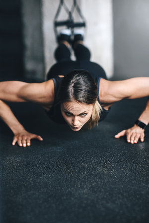 Theres no secret, just hard work and determination. an attractive young woman doing push ups in a...