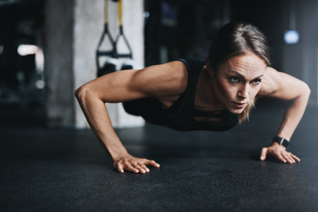 Stay consistent, stay fit. an attractive young woman doing push ups in a gym.の写真素材