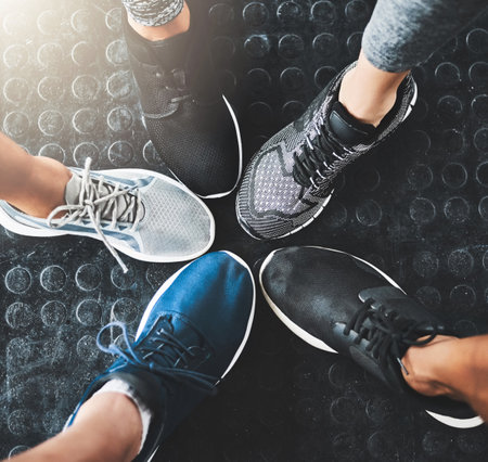 You know youre winning when youre wearing gym shoes. a group of people standing together in a circle at the gym.の写真素材